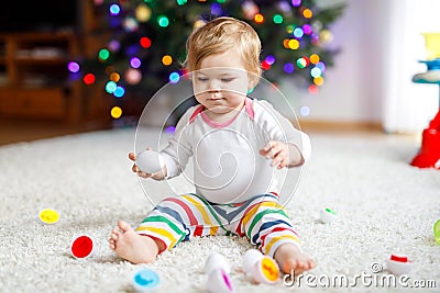 Adorable cute beautiful little baby girl playing with educational colorful shape sorter toy Stock Photo