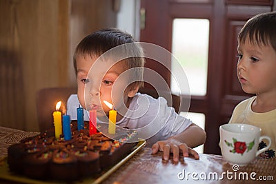 Adorable five year old boy celebrating his birthday and blowing Stock Photo