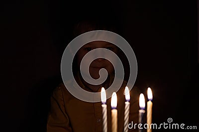 Adorable five year old kid celebrating his birthday and blowing candles on homemade baked cake, indoor. Birthday party for Stock Photo