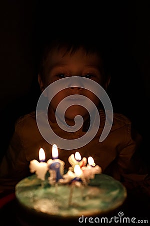 Adorable five year old kid celebrating his birthday and blowing candles on homemade baked cake, indoor. Birthday party Stock Photo