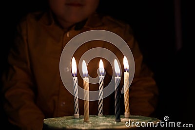 Adorable five year old kid celebrating his birthday and blowing candles on homemade baked cake, indoor. Birthday party for Stock Photo