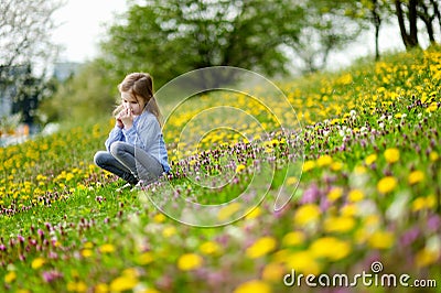 Adorable girl in blooming dandelion flowers Stock Photo