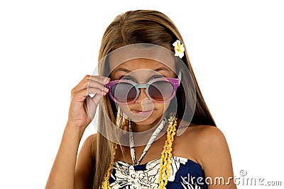 Adorable girl in island style dress peering over her sun glasses Stock Photo