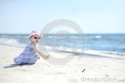 Adorable girl on a sunny sand beach Stock Photo