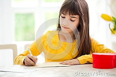 Adorable girl writing greeting card Stock Photo