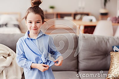 Adorable happy 5 years old child girl checking bow on her fashion shirt Stock Photo