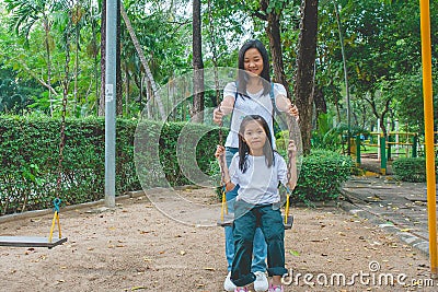 Adorable and Holiday Concept : Woman and child feeling funny and happiness on a swing at playground. Stock Photo
