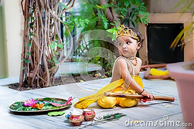 adorable infant dressed as hindu god krishna cute facial expression with flute at janmashtami Stock Photo