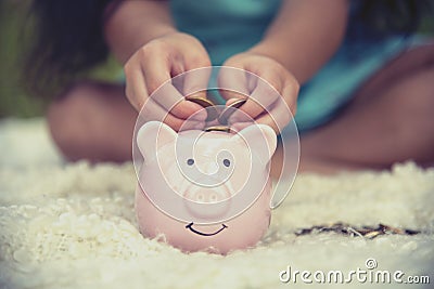 Adorable kids saving coins in piggy bank. Happy little investment saving money for happiness future. Girls smiling with happy Stock Photo