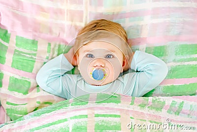 Adorable little baby girl sleeping in bed. Calm peaceful child dreaming during day sleep. Beautiful baby in parents bed Stock Photo