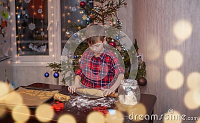 Adorable little boy is preparing the gingerbread, bake cookies in the Christmas kitchen Stock Photo