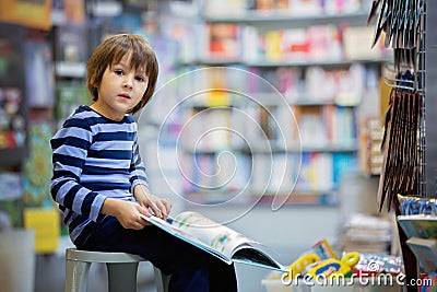 Adorable little child, boy, sitting in a book store Stock Photo