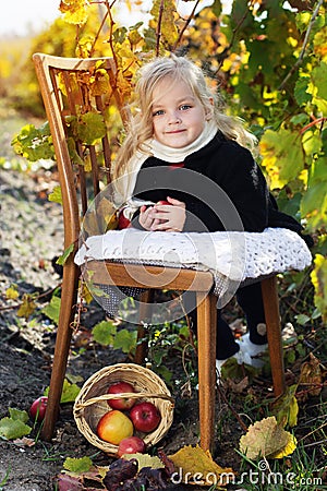 Adorable little girl with apples, autumn time Stock Photo