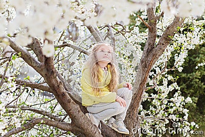 Adorable little girl in blooming cherry tree garden on beautiful spring day Stock Photo