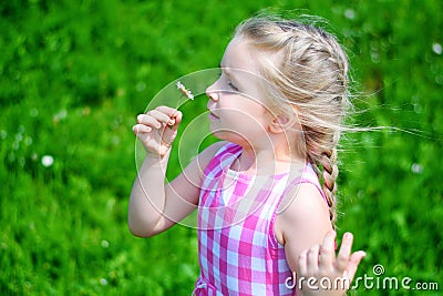 Adorable little girl with daisy on sunny summer day Stock Photo