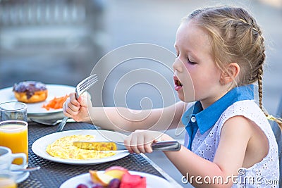 Adorable little girl having breakfast at outdoor Stock Photo