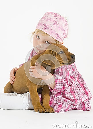 Adorable little girl is hugging her little puppy Stock Photo