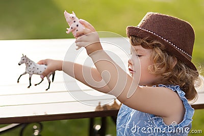 Adorable little girl play with animal toys Stock Photo