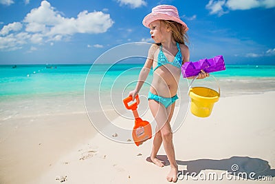 Adorable little girl playing with sand on a Stock Photo