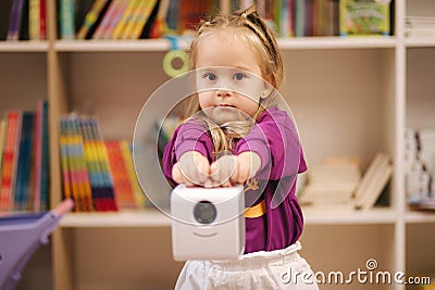 Adorable little girl shopping for toys. Cute female in toy store. Happy young girl selecting toy Stock Photo