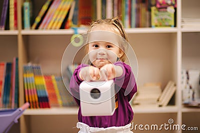 Adorable little girl shopping for toys. Cute female in toy store. Happy young girl selecting toy Stock Photo