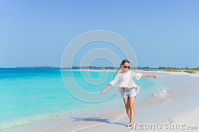 Adorable little girl walking along white sand Caribbean beach Stock Photo