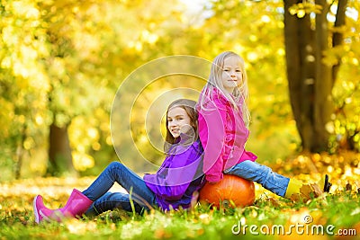 Adorable little girls having fun on a pumpkin patch on beautiful autumn day Stock Photo