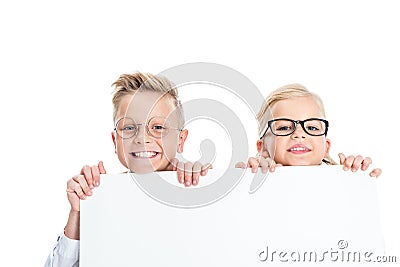 adorable little kids in eyeglasses holding blank banner and smiling at camera Stock Photo