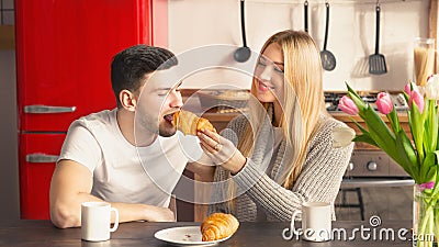 Adorable loving couple sharing breakfast together in kitchen Stock Photo