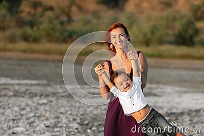 Adorable mother and child son having a good time together on the beach. Motherhood concept Stock Photo