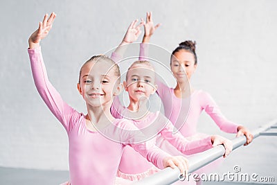 adorable multiethnic kids practicing ballet and smiling at camera Stock Photo