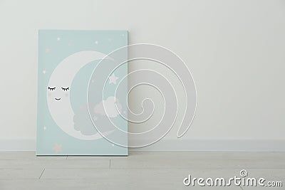 Adorable picture of moon on floor near wall, space for text. Children`s room interior element Stock Photo