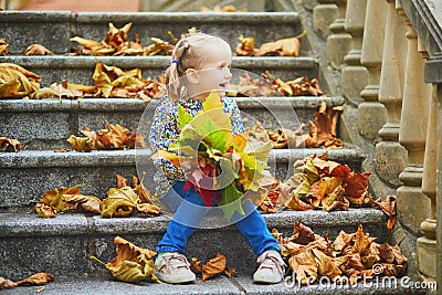 Adorable preschooler girl enjoying nice and sunny autumn day outdoors Stock Photo