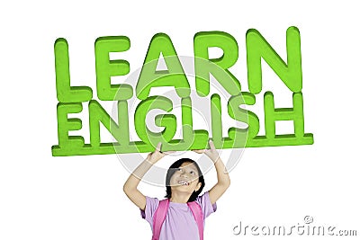 Adorable schoolgirl lifting word of Learn English Stock Photo