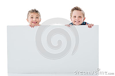 Adorable siblings holding blank white banner and smiling at camera Stock Photo