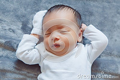 adorable sleeping Asian Chinese mixed race newborn baby girl boy lying on bed Stock Photo