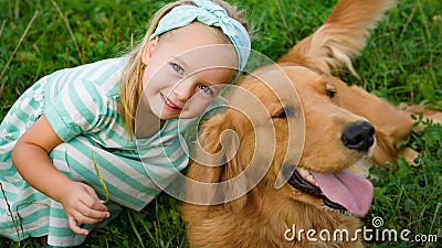 Adorable smiling little blond girl playing with her cute pet dog Stock Photo