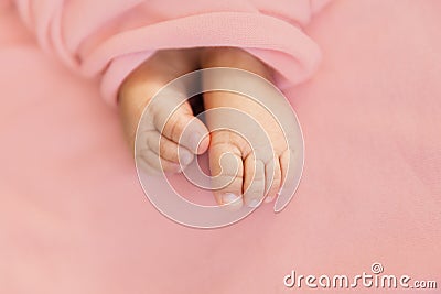 Adorable tine baby girl feet on soft pink background, maternity and babyhood concept Stock Photo