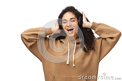 Adorable woman in casual hoodie using wireless earphones for listening music, teenager in headphones enjoying favourite Stock Photo