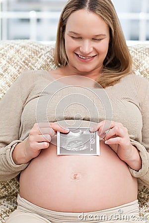 Adorable woman showing an echography to the camera Stock Photo