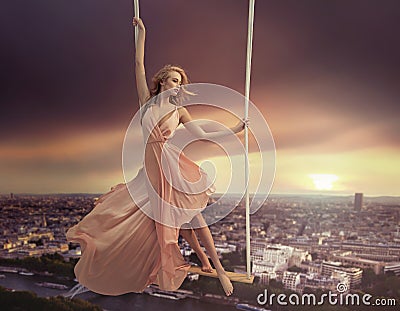 Adorable woman swinging above the city Stock Photo