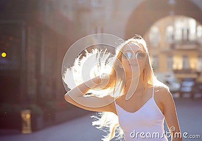 Adorable young model with long hair wearing glasses, posing at the passage in rays of sun. Copy space Stock Photo