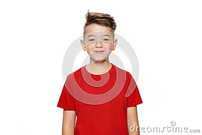 Adorable young teenage boy waist up studio portrait isolated over white background. Handsome boy looking at camera with smile. Stock Photo