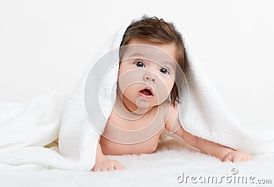 Adorably baby lie on white towel in bed. Happy childhood and healthcare concept Stock Photo