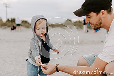 Adorably Perfect Young Father and Baby Toddler Son Family Having Fun Time at the Sandy Beach During Sunset Outside By the Ocean Wa Stock Photo