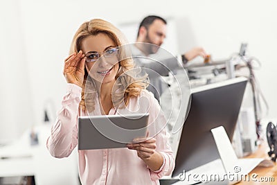 Beautiful woman in eyeglasses posing with tablet Stock Photo