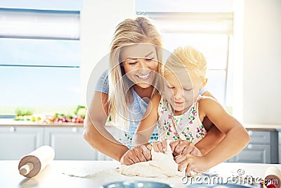Adoring young mother teaching her daughter to bake Stock Photo