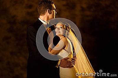 Adorning elegant fashion groom and bride is hugging on the back Stock Photo