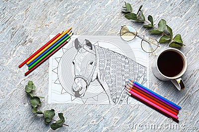 Adult anti stress coloring picture, pencils and cup of coffee on table, top view Stock Photo