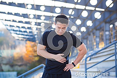 Adult asian athlete sportsman while jogging chest injury, severe heart attack pain, shortness of breath, male runner Stock Photo